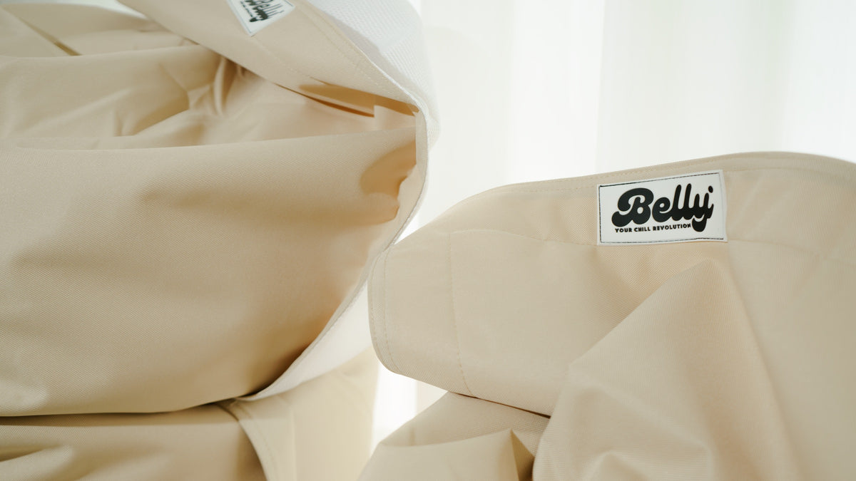 Dettaglio del tessuto beige e dell’etichetta di un pouf Belly Original